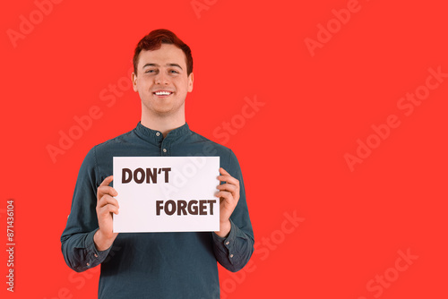 Young man holding paper wit...