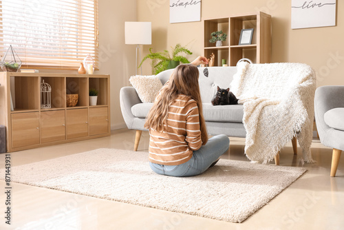 Woman playing with cute bla...