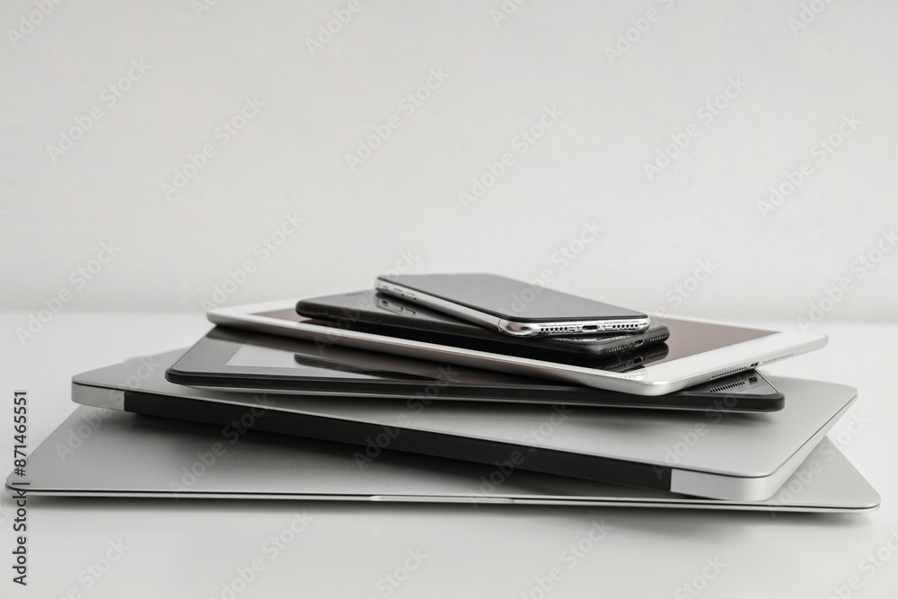 Stack of different modern gadgets on light background Stack of different modern gadgets on light background
