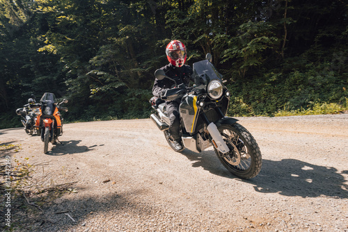 Obraz na płótnie Modern adventure motorcycle on a ride on gravel surface. Motorcycling in nature or offroad, enjoying freedom. Motorbike in the woods. Bike on a bend w salonie