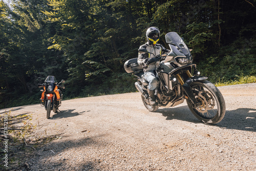 Obraz na płótnie Modern adventure motorcycle on a ride on gravel surface. Motorcycling in nature or offroad, enjoying freedom. Motorbike in the woods. Bike on a bend w salonie