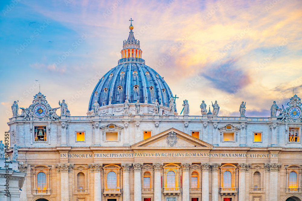 Obraz premium A scenic view of the iconic dome of St. Peters Basilica in Vatican City at sunset. The buildings facade and dome are illuminated by the warm glow of the evening light.