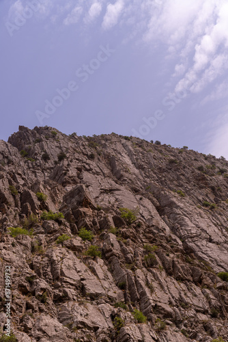 A rocky mountain with a blue sky in the background