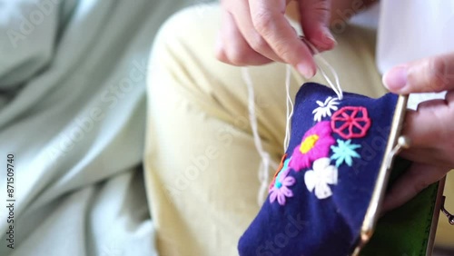 Young woman embroidering handmade picture flower on clasp coin purse. Handicraft, hobby, diy for decoration home concept