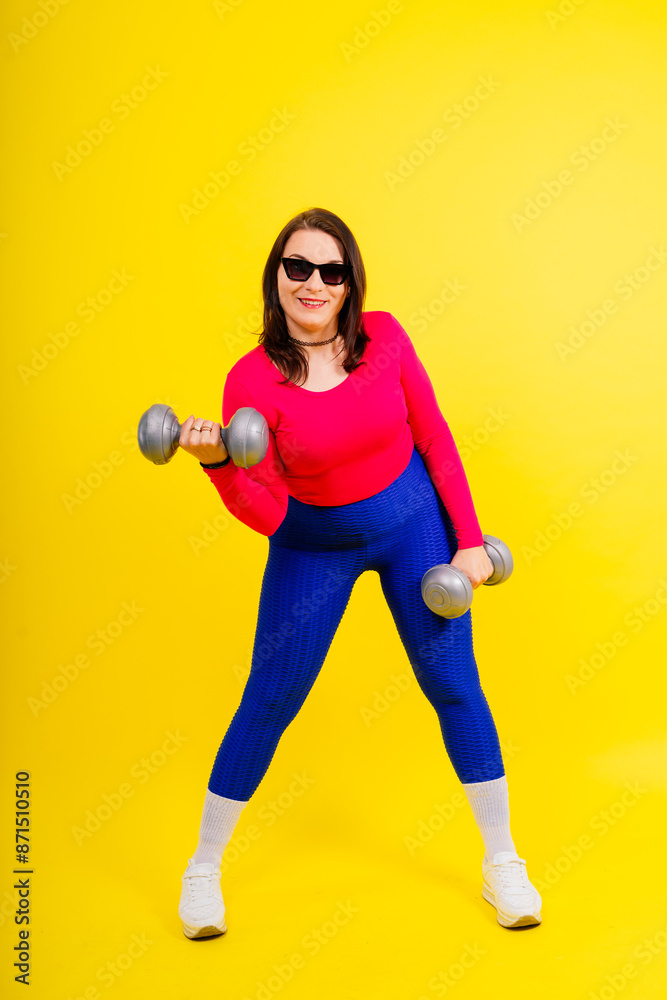 Sporty model with curvy figure with dumbbells. Dynamic movement. Motivation and healthy lifestyle Sporty model with curvy figure with dumbbells. Dynamic movement. Motivation and healthy lifestyle