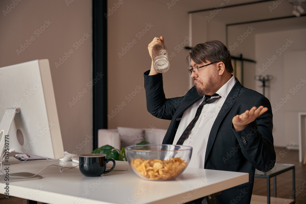 Businessman alcoholic fooling around with empty bottle at home office Businessman alcoholic fooling around with empty bottle at home office