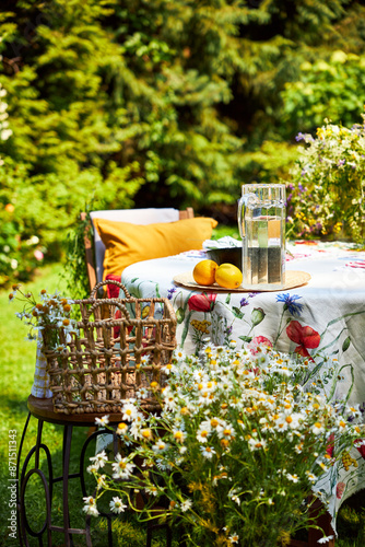 A bright, festive outdoor garden setting in a yellow and red palette with wildflowers, berries and watermelon