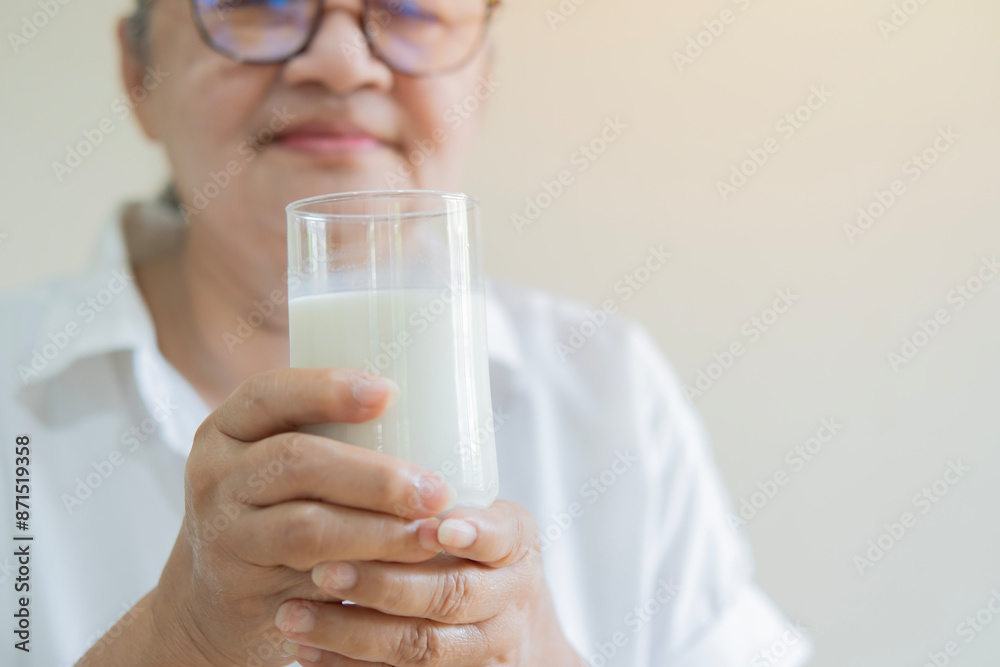 Elderly Asian female holding glass of fresh milk for dairy breakfast, Retirement people healthy lifestyle concept Elderly Asian female holding glass of fresh milk for dairy breakfast, Retirement people healthy lifestyle concept