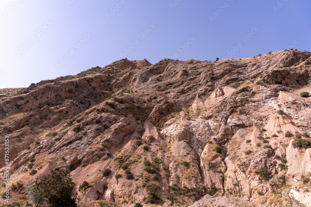 Fototapeta premium A rocky mountain with a clear blue sky in the background