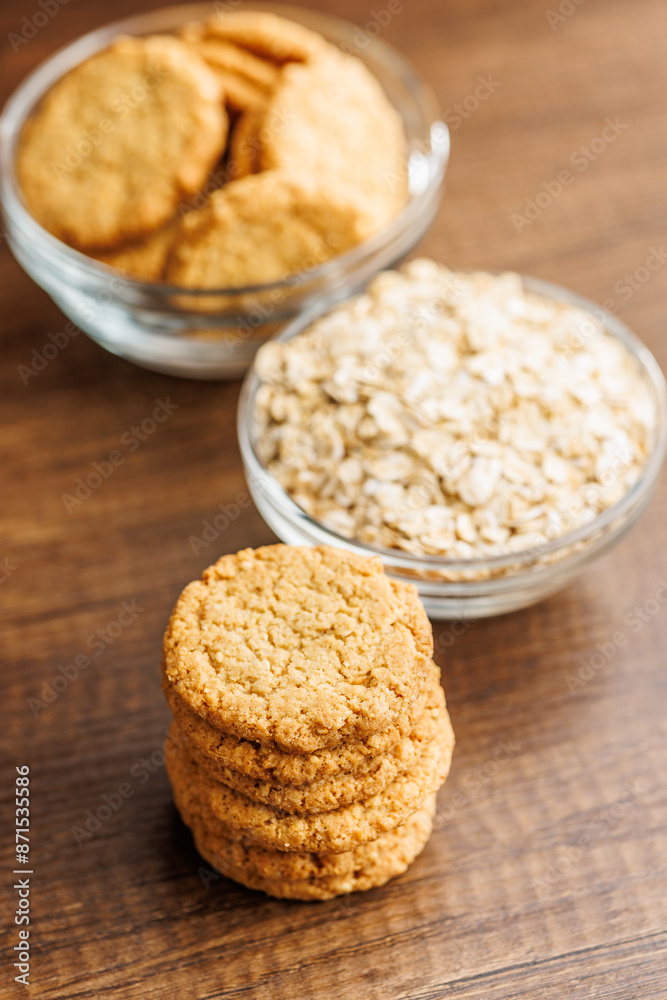 Tasty oatmeal cookies and rolled oat on wooden table. Tasty oatmeal cookies and rolled oat on wooden table.