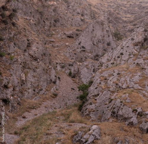 A rocky hillside with a small stream running through it