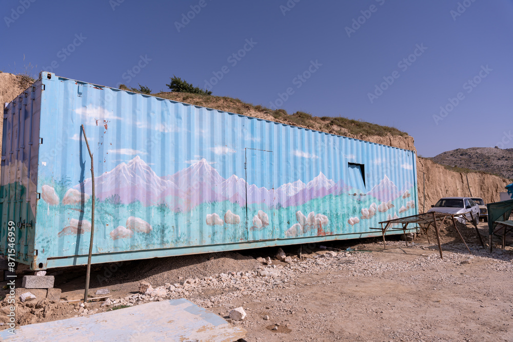 Fototapeta premium A blue container with mountains painted on it
