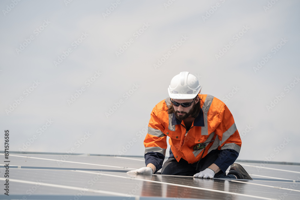 Obraz premium Male engineer checking solar cell or photovoltaic cell by electronic device installed on the roof of the factory. Technician worker repair or inspect the system. Industrial renewable energy concept
