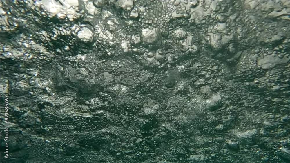 Close up underwater view of water surface with waterdrops and air bubbles during heavy pouring rain, slow motion Close up underwater view of water surface with waterdrops and air bubbles during heavy pouring rain, slow motion