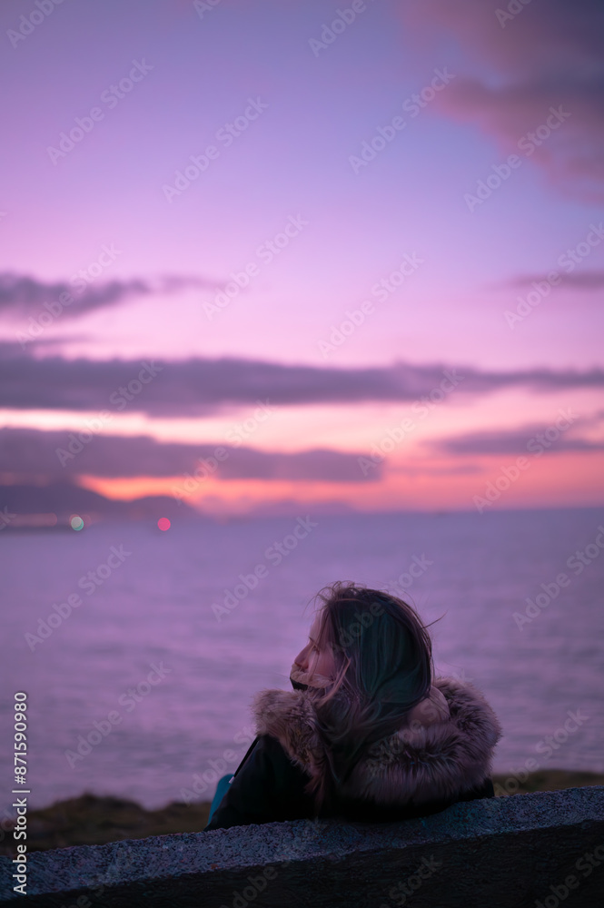 Girl looking to the sunset over the viscay sea in the Basque Country Girl looking to the sunset over the viscay sea in the Basque Country