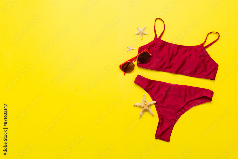 Fototapeta premium Traveler accessories, women summer bikini set swimsuit on table background with empty space for text. Travel vacation concept. Flat lay, top view Female sexy swimwear