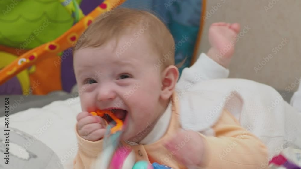 Adorable happy blonde infant baby playing with kids toys at home while sitting on carpet floor in living room. Portrait of smiling cute child toddler using colorful toys, copy space Adorable happy blonde infant baby playing with kids toys at home while sitting on carpet floor in living room. Portrait of smiling cute child toddler using colorful toys, copy space