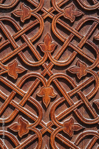 floral oriental uzbek carved ornament pattern on a brown wooden door in Uzbekistan in Tashkent close-up