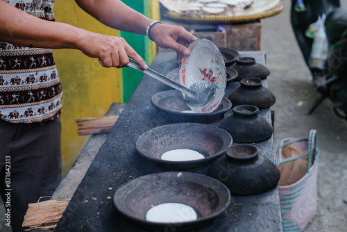 A man's hands cook pancakes. Serabi is a traditional pancake from Indonesia photo