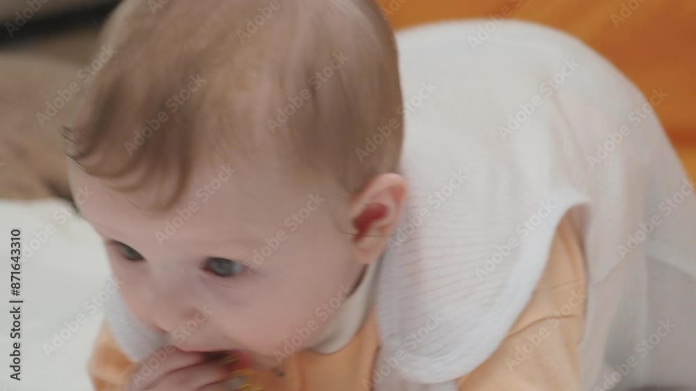 Adorable happy blonde infant baby playing with kids toys at home while sitting on carpet floor in living room. Portrait of smiling cute child toddler using colorful toys, copy space Adorable happy blonde infant baby playing with kids toys at home while sitting on carpet floor in living room. Portrait of smiling cute child toddler using colorful toys, copy space