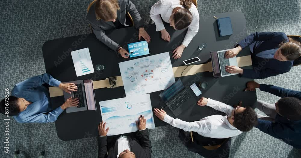 Zoom In Top Down View: Diverse Team of Professional Managers And Specialists Analyzing Business Data and Strategies in an Office. Collaboration Of Colleagues With Laptop Computers, Mindmap, And Graphs