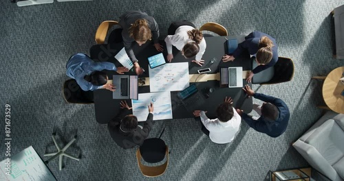 Zoom Out Top Down View: Diverse Team Of Business Professionals With Laptops Entering The Conference Room And Sitting Behind Table To Discuss Financial Data And Project Mindmap in Corporate Office.
