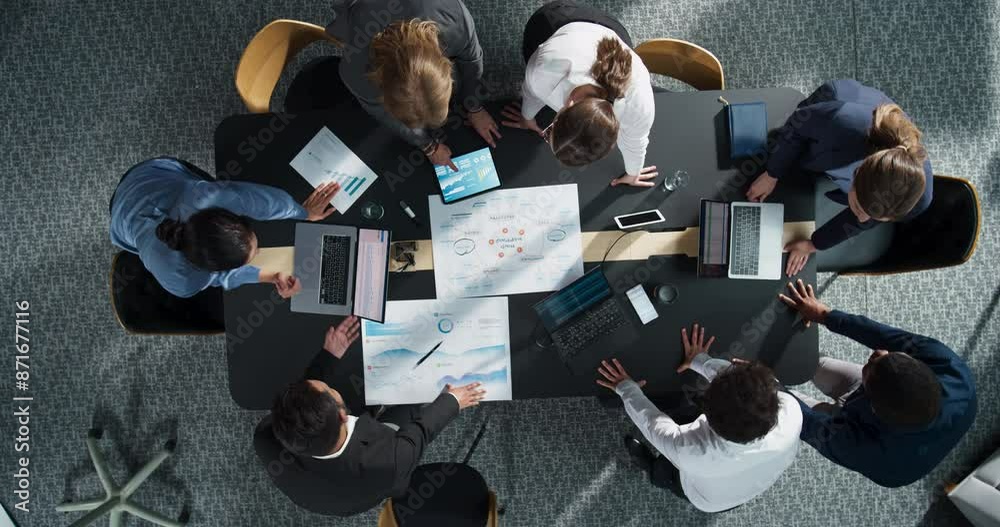 Top Down View Of Diverse Team Of Business Professionals And Managers With Laptops Entering The Conference Room And Sitting Behind Table To Discuss Financial Data And Sales Reports In Corporate Office.