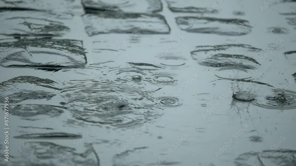 Rain falling and pooling on a cobblestone side walk or street in Slow Motion Rain falling and pooling on a cobblestone side walk or street in Slow Motion