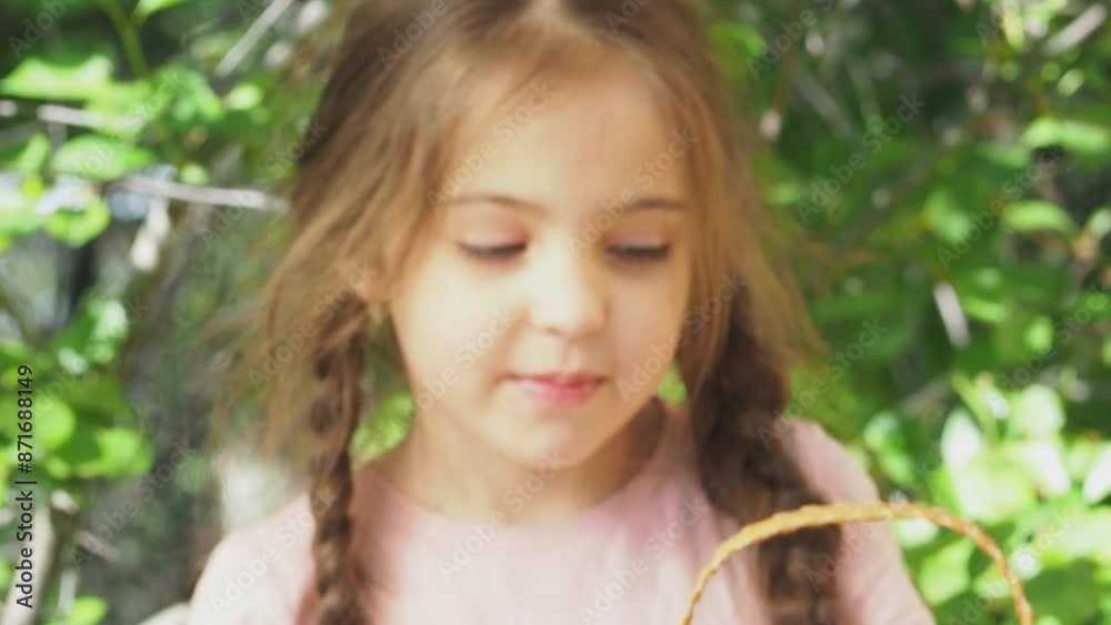 Cute girl tasting picked strawberries in the garden. Smiling girl holding strawberries in the garden. Happy child enjoying fresh picked strawberries in the garden Cute girl tasting picked strawberries in the garden. Smiling girl holding strawberries in the garden. Happy child enjoying fresh picked strawberries in the garden