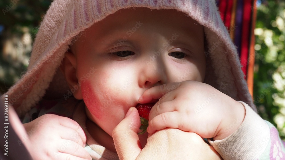 first food for babies. The boy tries strawberries for the first time. funny baby trying a berry. Happy summer - Lovely girl with fresh blueberries in the garden first food for babies. The boy tries strawberries for the first time. funny baby trying a berry. Happy summer - Lovely girl with fresh blueberries in the garden