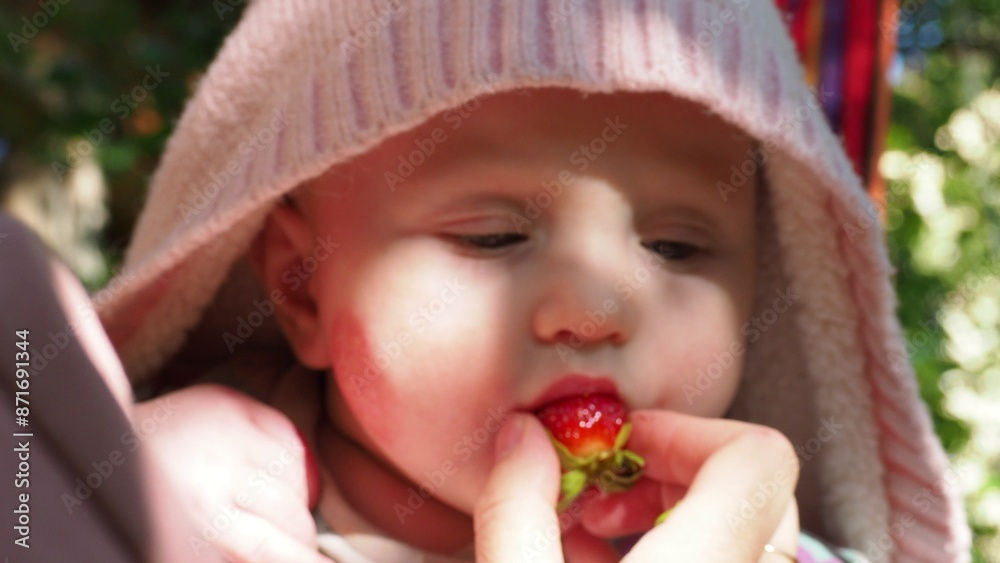 first food for babies. The boy tries strawberries for the first time. funny baby trying a berry. Happy summer - Lovely girl with fresh blueberries in the garden first food for babies. The boy tries strawberries for the first time. funny baby trying a berry. Happy summer - Lovely girl with fresh blueberries in the garden