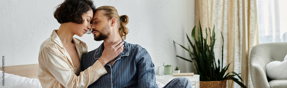 Fototapeta premium A loving couple cuddles on a bed at home, enjoying a relaxing moment together.