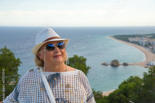 Elegant lady in a hat enjoying the summer sea view