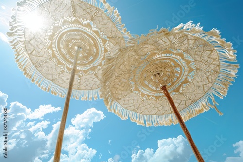 Two umbrellas with fringes on them are in the sky