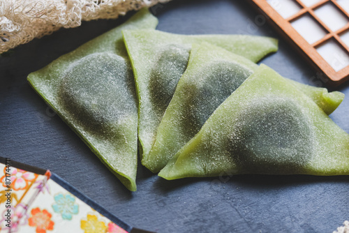 Wallpaper Mural Four Nama-Yatsuhashi with Matcha flavor on a black plate. Yatsuhashi is a Japanese confection. It is one of the best known regional products from Kyoto. Torontodigital.ca