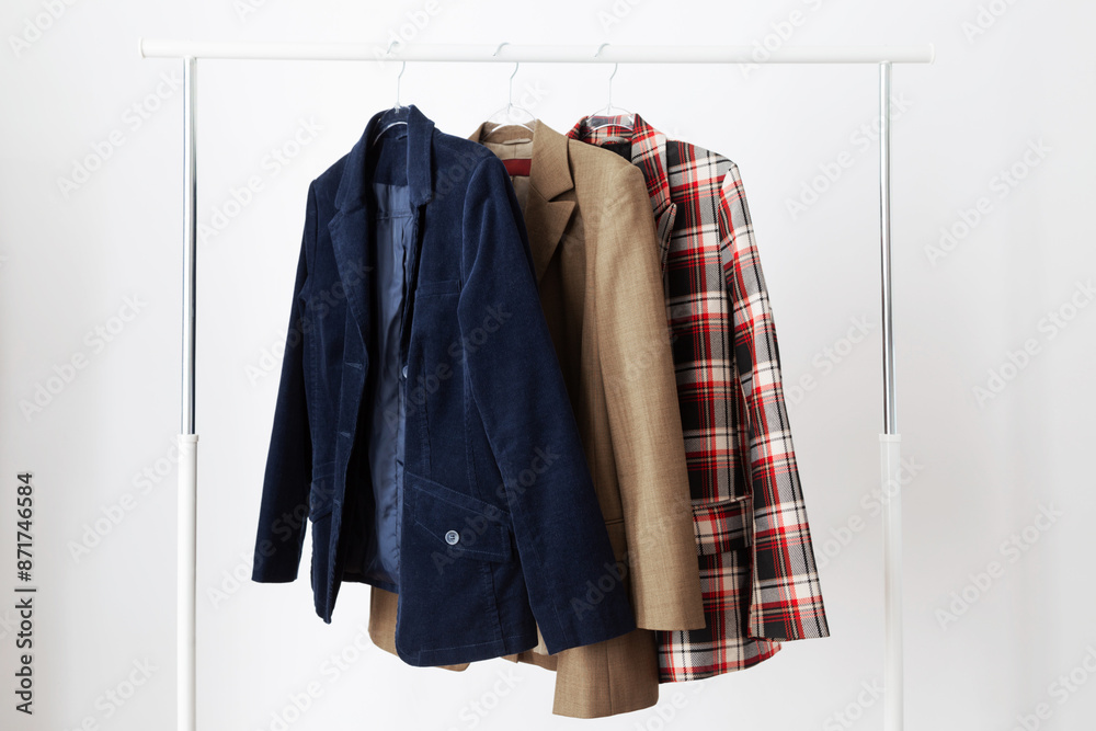 several women's jackets on a hanger on a white background several women's jackets on a hanger on a white background