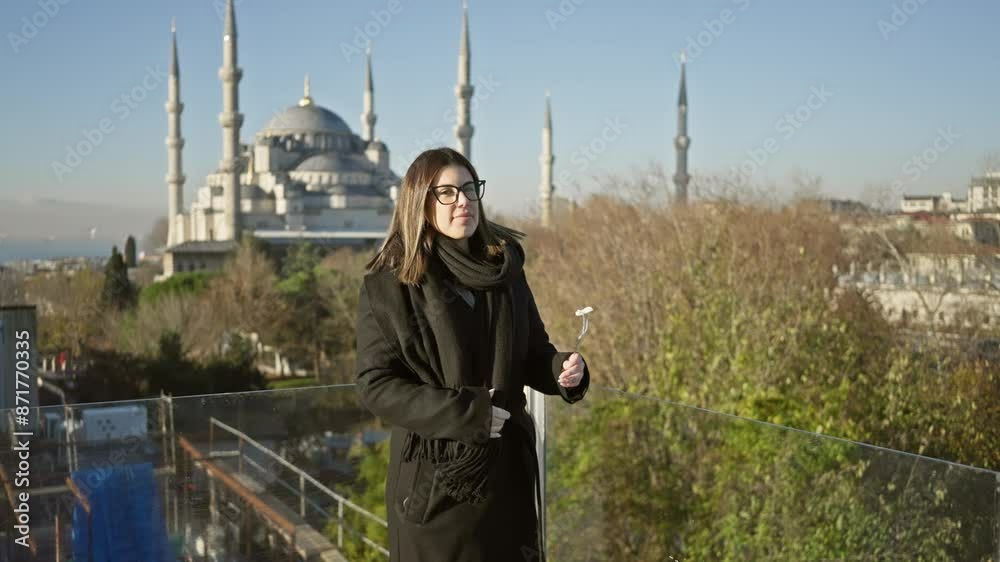 A joyful woman feeds a seagull against the backdrop of sultan ahmet mosque in istanbul, turkey