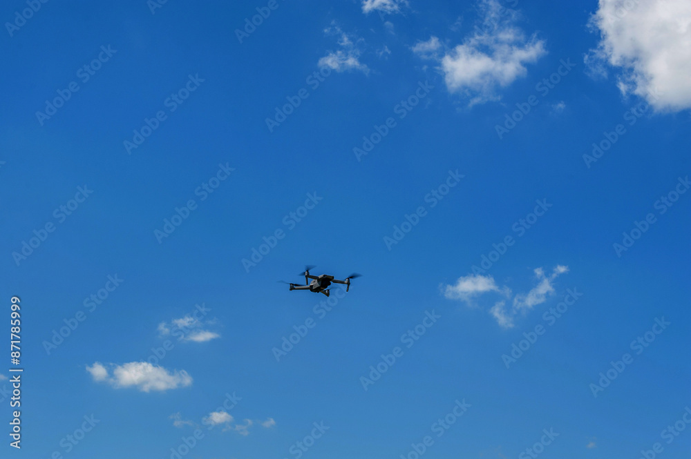 Drone flying in fromt of a blue sky Drone flying in fromt of a blue sky
