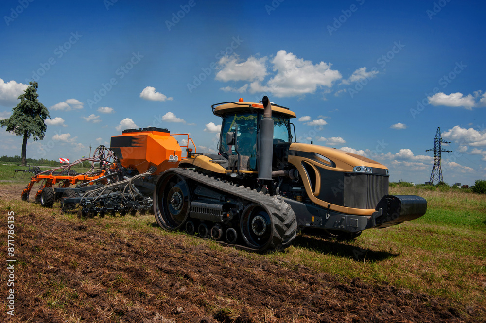 a tracked tractor pulls a precision seed drill, movement in operation a tracked tractor pulls a precision seed drill, movement in operation