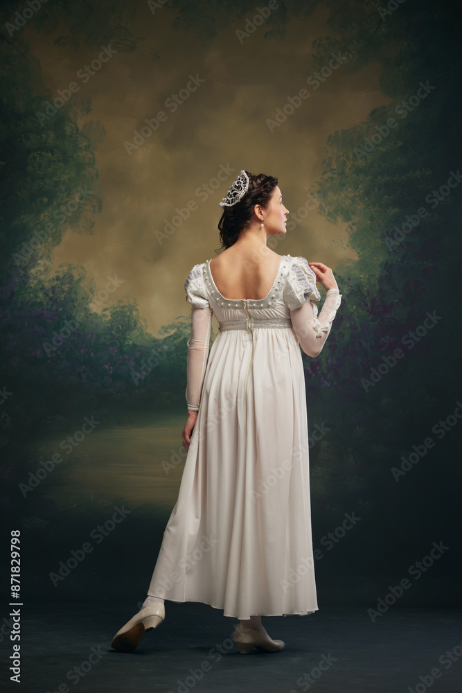 Timeless Grace. Elegant young woman in white dress with silver hair accessory standing against vintage green background. Juliette. Concept of history, comparison of eras, remake, beauty and fashion Timeless Grace. Elegant young woman in white dress with silver hair accessory standing against vintage green background. Juliette. Concept of history, comparison of eras, remake, beauty and fashion