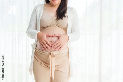 An Asian young pregnant wife relaxes at home, her hand gently resting on her belly, filled with love and anticipation as she embraces the journey of impending motherhood. Free Download An Asian young pregnant wife relaxes at home, her hand gently resting on her belly, filled with love and anticipation as she embraces the journey of impending motherhood. - GFXLoad