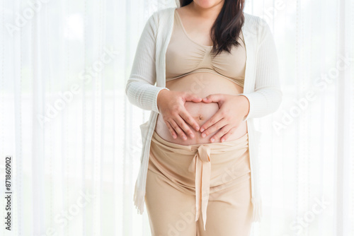 An Asian young pregnant wife relaxes at home, her hand gently resting on her belly, filled with love and anticipation as she embraces the journey of impending motherhood. Free Download An Asian young pregnant wife relaxes at home, her hand gently resting on her belly, filled with love and anticipation as she embraces the journey of impending motherhood. - GFXLoad