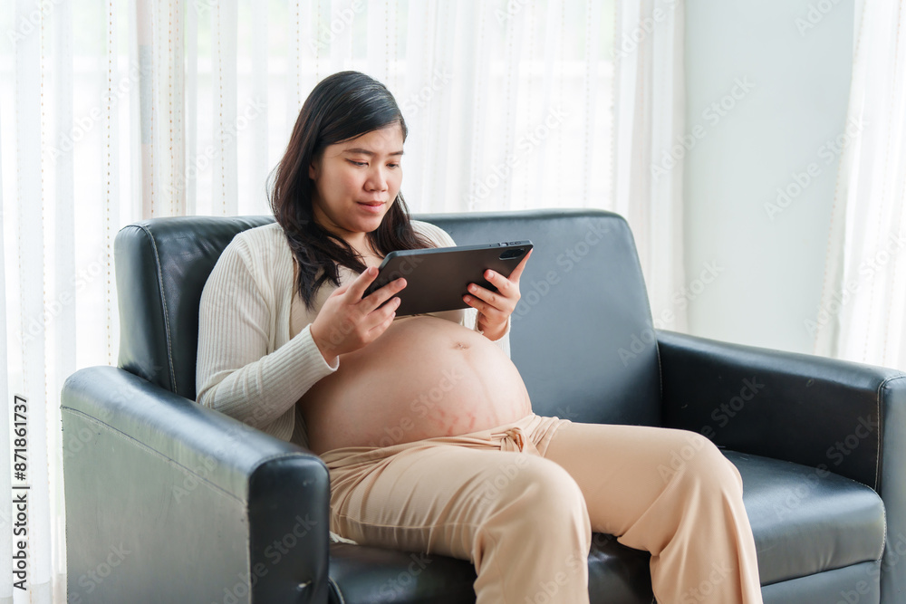 An Asian young pregnant wife relaxes on the sofa at home, filled with love and anticipation, preparing for the arrival of her baby while embracing the journey of motherhood. An Asian young pregnant wife relaxes on the sofa at home, filled with love and anticipation, preparing for the arrival of her baby while embracing the journey of motherhood.