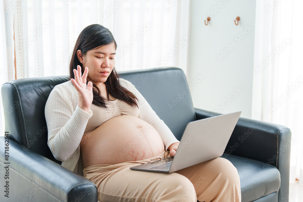 An Asian young pregnant wife relaxes on the sofa at home, filled with love and anticipation, as she embraces the journey of motherhood and prepares for her baby's arrival. An Asian young pregnant wife relaxes on the sofa at home, filled with love and anticipation, as she embraces the journey of motherhood and prepares for her baby's arrival.