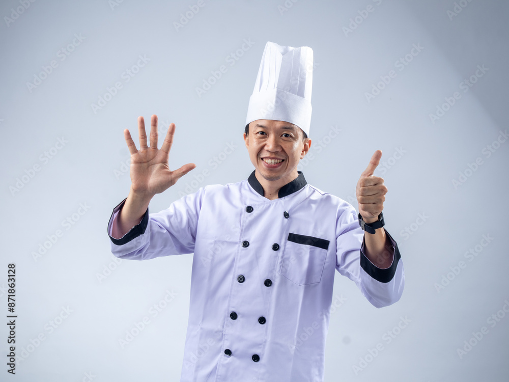 A smiling Asian male chef in a white uniform and hat holds up six fingers, signifying the number six, against a light blue background. The setting is professional and engaging A smiling Asian male chef in a white uniform and hat holds up six fingers, signifying the number six, against a light blue background. The setting is professional and engaging
