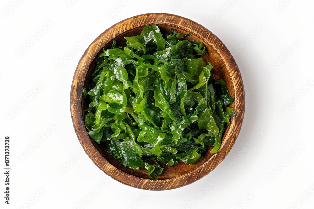 Brown wooden bowl with Chuka seaweed salad on white background top view Brown wooden bowl with Chuka seaweed salad on white background top view