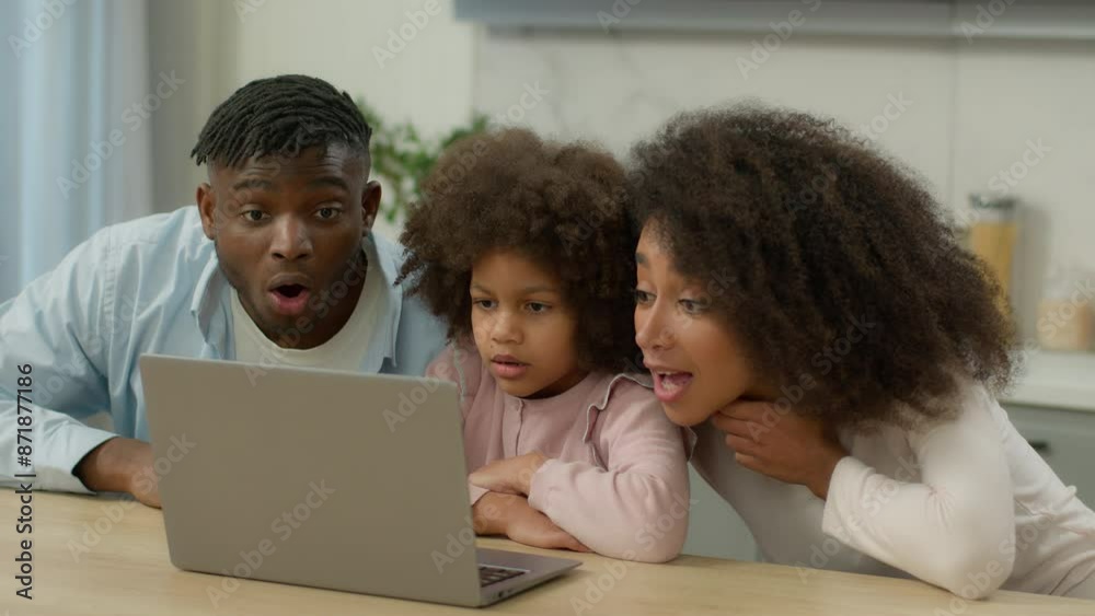 African American ethnic family parents father man woman mother with little child daughter girl kid using laptop together shock wonder amazed good news win computer winning success at home kitchen yell African American ethnic family parents father man woman mother with little child daughter girl kid using laptop together shock wonder amazed good news win computer winning success at home kitchen yell