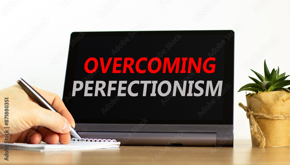 Overcoming perfectionism symbol. Concept words Overcoming perfectionism on beautiful black pad. Beautiful white background. Businessman hand. Business Overcoming perfectionism concept. Copy space.