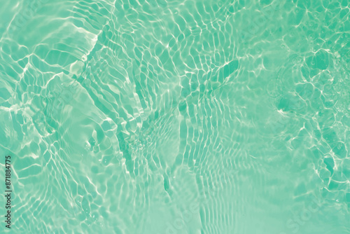 Blue water with ripples on the surface. Defocus blurred transparent blue colored clear calm water surface texture with splashes and bubbles. Water waves with shining pattern texture background.