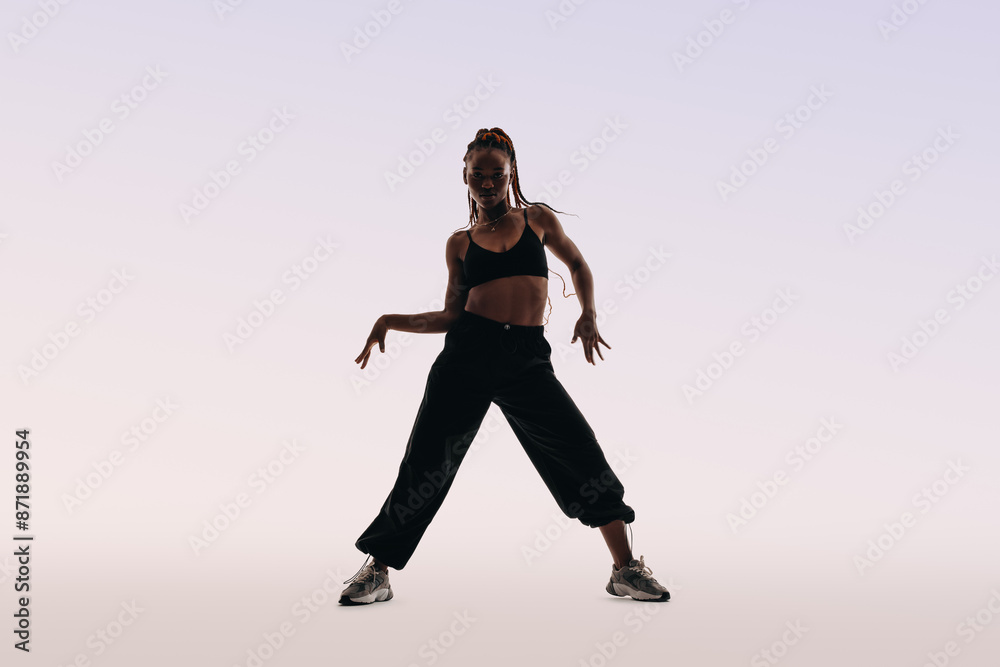 Portrait of a young woman dancing with energetic moves in a studio Portrait of a young woman dancing with energetic moves in a studio